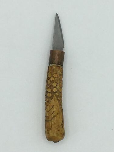 Knife with carved wooden handle and small blade.