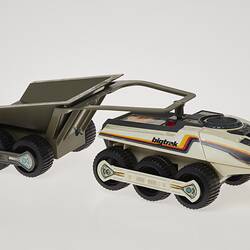 Cream six-wheeled toy truck with grey two-wheeled trailer. Stickers on sides. Right profile.