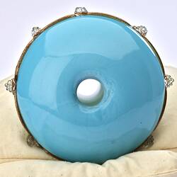 Round base of pale blue opaque glass vase. Hole in centre.