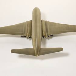 Silver model aeroplane, four wheels beneath each wing and two front wheels. British flag painted on tail.