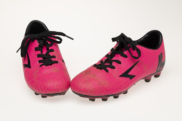 Pair of pink Australian Rules football boots with black laces, lining and soles.