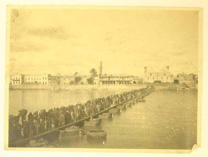 People walking across a pontoon bridge over the Tigris River.
