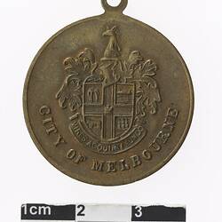Round medal with coat of arms, text below.