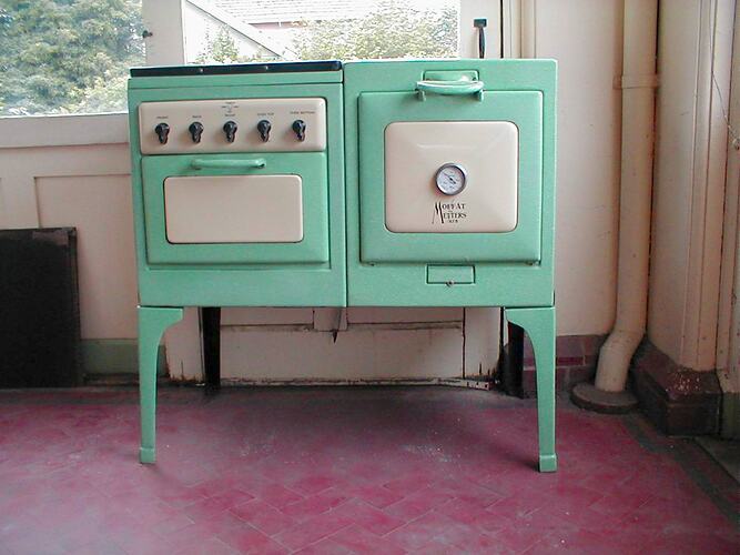Green and cream old fashioned electric stove in a house.