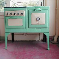 Green and cream old fashioned electric stove in a house.