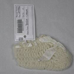Knitted baby bootie with ribbon
