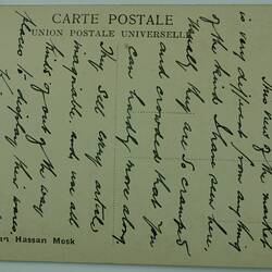 Postcard on green paper with black handwritten text.