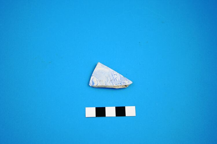 Fragment of cup with blue transfer print.