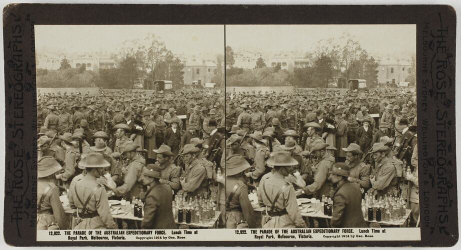 Crowd of soldiers, with table containing drink bottles in foreground.