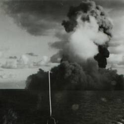 Explosion with large smoke cloud on open water.