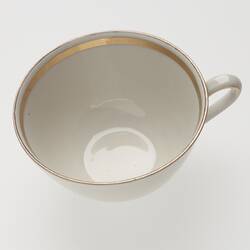 White china cup with gold rim and detail.
