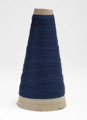 Cardboard cone with navy blue wool wound around.