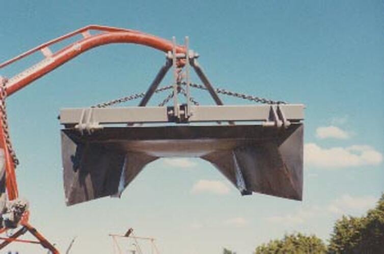 A jib crane lifting a metal object.