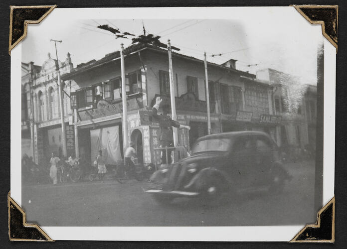 Double story building on street corner with car in foreground.