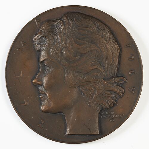 Brown medal with profile of woman facing left.