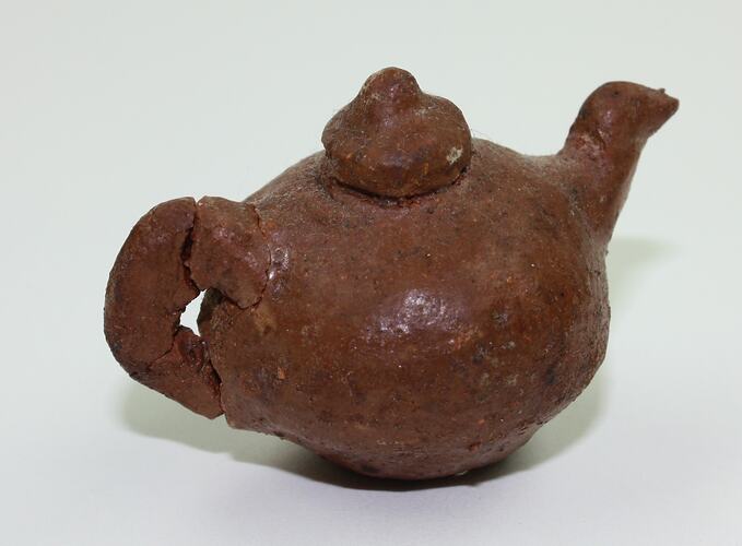 Clay toy teapot, side view.