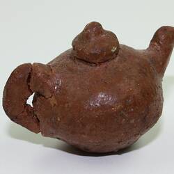 Clay toy teapot, side view.