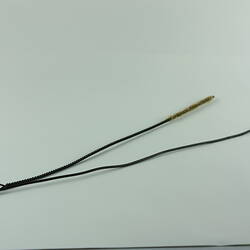 Two metal rod-like cleaning tools, one twisted arm with narrow brush at end.