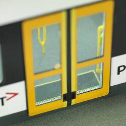 Tram model of articulated, low-floor tram. Detail (external) of yellow side doors.