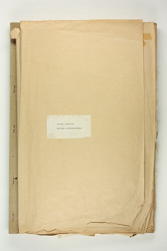 Brown paper stapled scrapbook with white label featuring typed text.