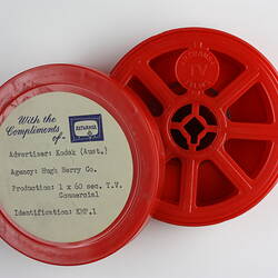 Opened circular plastic film container with reel inside.