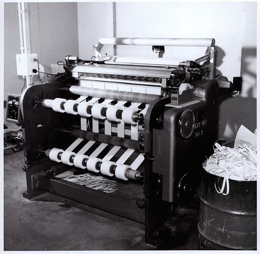Paper slitting machine with worker visible behind.