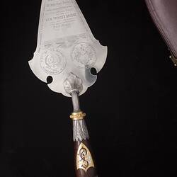 Back of silver decorative engraved trowel with detailed handle.