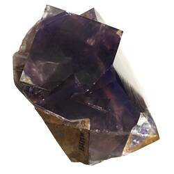 Purple and brown mineral with square crystal shapes.