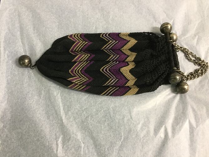 Bell shaped crocheted black bag with zig zag pattern. Chain handle.