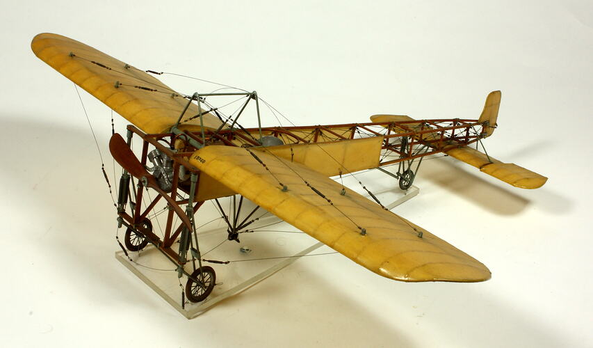 Model aeroplane with exposed wooden frame and off white panelling. Side view.