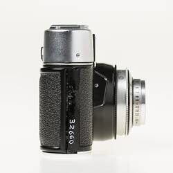 Black camera, metal top section. Right profile.
