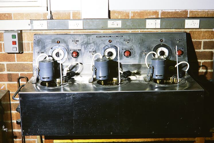 Control panel with pipes and cylinders attached.