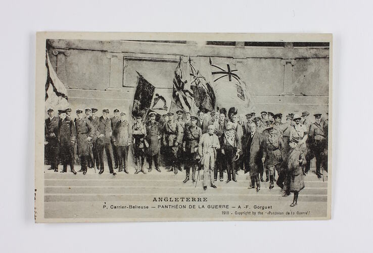 Front of postcard showing group of men on steps with flags.