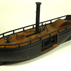 Three quarter view of wooden paddle steamer model.