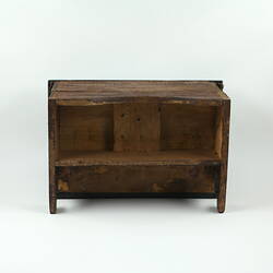 Underside of wooden toy piano.