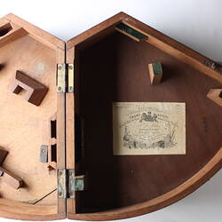 Wedge shaped wooden box, opened.