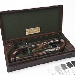 Wooden case, green lining. Contains two pistols.