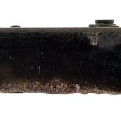 Side view of black metal box with larger thin piece along top.