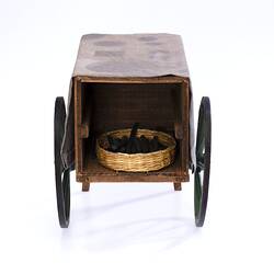 Miniature wooden coffee hand cart with two legs, two wheels. Basket on internal shelf. Fabric cover on top.