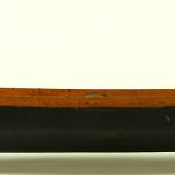 Wooden boat with black hull, facing left.