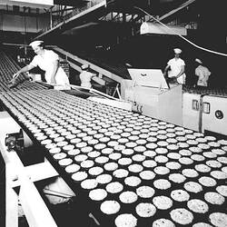 Negative - Female Factory Employee Removing Biscuits From a Conveyor, circa 1965.