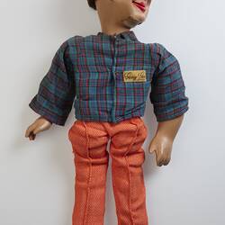 Doll with red pants, blue top and short brown hair.