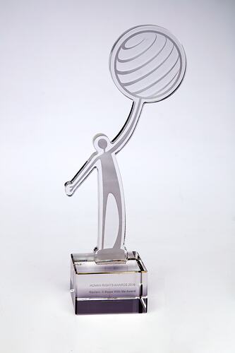 Clear perspex award in the form of a figure holding up a globe.