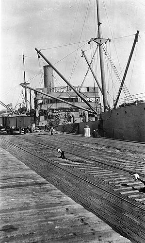 Loading grain from rail trucks to ships at pier, Portland, 1921.