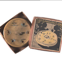 Spinning game, wooden plate with numbers. metal nails and holes. Cardboard box.