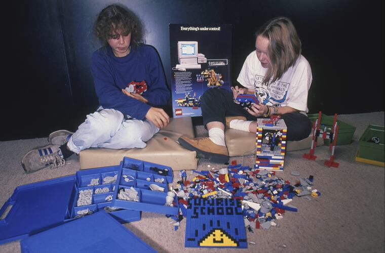 A group of students sitting on the floor playing with Lego.