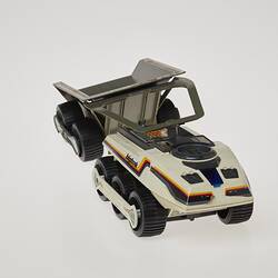 Cream six-wheeled toy truck. Stickers on sides. Right front three-quarter profile.