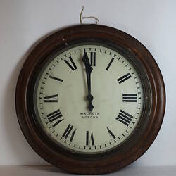 Circular wooden clock varnished with white face.