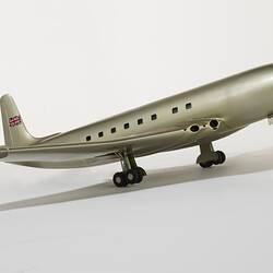 Silver model aeroplane, four wheels beneath each wing and two front wheels. British flag painted on tail.