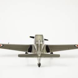Back view of model aeroplane, silver with black propeller and wheels. Red, white, blue roundels on wings.